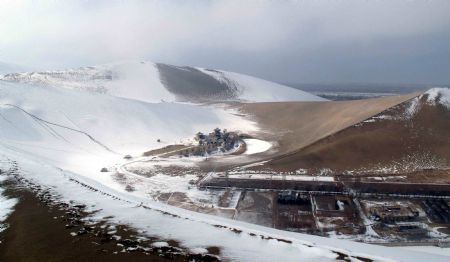 Photo taken on Dec. 14, 2009 shows the snow scene in Yueyaquan Spring (Crescent Spring) near Mingshashan, famouse tourists attractions in Dunhuang of northwest China&apos;s Gansu Province. [Zhang Weixian/Xinhua]