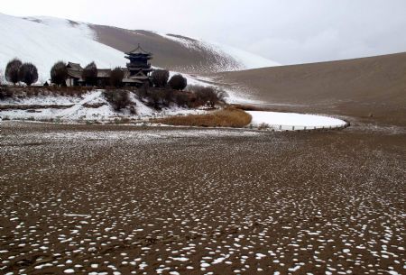 Photo taken on Dec. 14, 2009 shows the snow scene in Yueyaquan Spring (Crescent Spring) near Mingshashan, famouse tourists attractions in Dunhuang of northwest China&apos;s Gansu Province. [Zhang Weixian/Xinhua] 