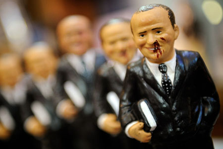 Dolls in the likeness of Italian Prime Minister Silvio Berlusconi with bleeding nose and mouth are sold after the attack in Naples, Italy, December 15, 2009.[Xinhua/AFP]