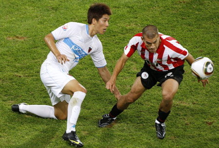 Pohang Steelers&apos; Kim Meung Chung challenges Estudiantes&apos; Maxi Nunez (R) during their FIFA Club World Cup semi-final soccer match at Mohammed bin Zayed stadium in Abu Dhabi December 15, 2009. Pohang Steelers lost 1-2.[Xinhua/Reuters]