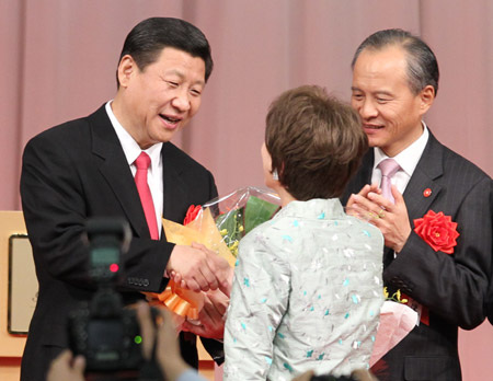Chinese Vice President Xi Jinping (L) receives a flower bouquet from Japanese singer Yoko Seri upon his arrival at a welcoming reception jointly held by seven Japanese organizations for Japan-China friendship and four organizations of local overseas Chinese in Tokyo, Japan, Dec. 15, 2009. [Xinhua]