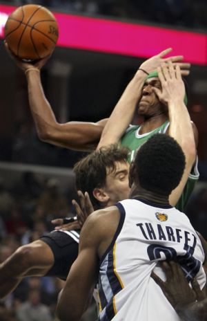 Boston Celtics guard Rajon Rondo (C) shoots under pressure by Memphis Grizzlies center Marc Gasol of Spain during the first half of NBA basketball action in Memphis, Tennessee December 14, 2009. 