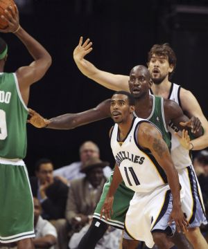 Boston Celtics guard Rajon Rondo looks for an open man as Memphis Grizzlies center Marc Gasol (R) and guard Mike Conley double team Celtics forward Kevin Garnett during the second half of NBA basketball action in Memphis, Tennessee December 14, 2009.