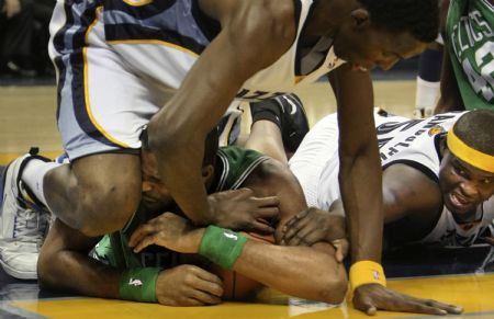 Memphis Grizzlies center Hasheem Thabeet (L) and forward Zach Randolph (R) try to pry the ball away from Boston Celtics forward Shelden Williams during the first half of their NBA basketball game in Memphis, Tennessee December 14, 2009.