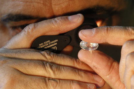 Israeli diamantaire Avraham Eshed inspects a diamond at the Israel Diamond Exchange in Ramat Gan near Tel Aviv December 15, 2009.