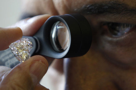 Israeli diamantaire Avraham Eshed inspects a diamond at the Israel Diamond Exchange in Ramat Gan near Tel Aviv December 15, 2009.