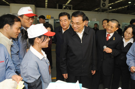 Chinese Vice Premier Li Keqiang (C) talks with workers of Galanz Group in Zhongshan City, south China's Guangdong Province, Dec. 15, 2009. Li Keqiang made an inspection tour in Guangdong from Dec. 14 to Dec. 16.(Xinhua/Huang Jingwen)