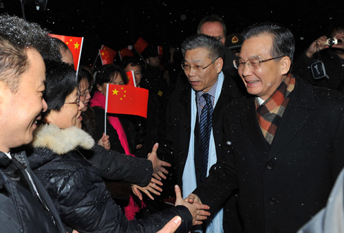 Chinese Premier Wen Jiabao (R, 1st) is greeted by representatives of overseas Chinese and Chinese students studying in Denmark after his special plane arrived in Copenhagen, December 16, 2009. [Xinhua]
