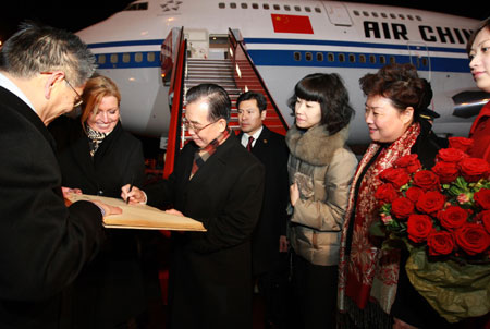 Chinese Premier Wen Jiabao (3rd, L) signs his autograph on the comment book of honored guests after he arrives at Copenhagen, capital of Denmark , on Dec. 16, 2009. Wen Jiabao arrived here Wednesday evening for the ongoing UN Climate Change Conference. [Xinhua]