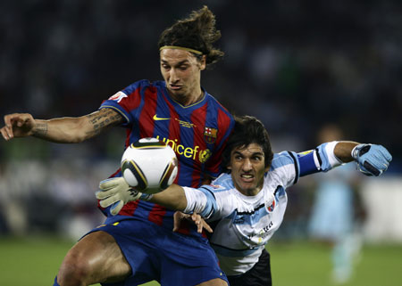 Barcelona&apos;s Zlatan Ibrahimovic battles for the ball with Atlante&apos;s goalkeeper Federico Vilar (R) during their FIFA Club World Cup semi-final soccer match at Zayed Sports City stadium in Abu Dhabi December 16, 2009. [Xinhua/Reuters]