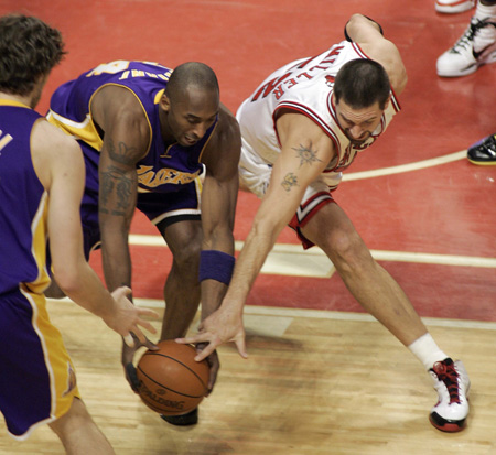 Los Angeles Lakers guard Kobe Bryant (C) battles Chicago Bulls center Brad Miller (R) for the loose ball while Lakers forward Pau Gasol looks on in the first quarter of their NBA basketball game in Chicago December 15, 2009. [Xinhua/Reuters]