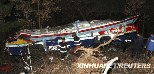 Rescue workers search for victims after a bus fell from a road in Gyeongju, about 370 km (230 miles) southeast of Seoul, December 16, 2009. At least 17 South Korean senior citizens were killed and 14 others injured on Wednesday when a tour bus plunged off a cliff on during a spa trip, AFP reported. [Xinhua/Reuters]