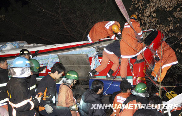 Rescue workers search for victims after a bus fell from a road in Gyeongju, about 370 km (230 miles) southeast of Seoul, December 16, 2009. At least 17 South Korean senior citizens were killed and 14 others injured on Wednesday when a tour bus plunged off a cliff on during a spa trip, AFP reported. [Xinhua/Reuters]