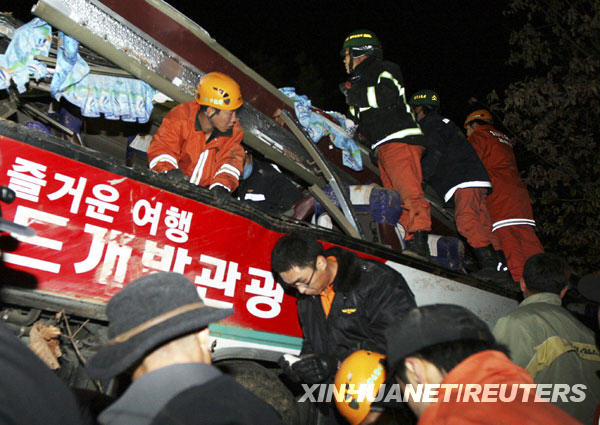 Rescue workers search for victims after a bus fell from a road in Gyeongju, about 370 km (230 miles) southeast of Seoul, December 16, 2009. At least 17 South Korean senior citizens were killed and 14 others injured on Wednesday when a tour bus plunged off a cliff on during a spa trip, AFP reported. [Xinhua/Reuters]