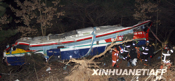 Rescue workers search for victims after a bus fell from a road in Gyeongju, about 370 km (230 miles) southeast of Seoul, December 16, 2009. At least 17 South Korean senior citizens were killed and 14 others injured on Wednesday when a tour bus plunged off a cliff on during a spa trip, AFP reported. [Xinhua/AFP]