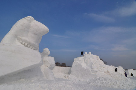 A snow sculptor works on snow carvings at the Jiangxindao Snow Castle in Mudanjiang City of northeast China&apos;s Heilongjiang Province, Dec. 16, 2009. [Xinhua]