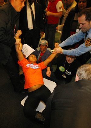 Activists are evacuated by security from the plenary hall of the Bella Center during a sit-in demonstration, Copenhagen, Dec. 16,2009