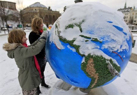 People clean the snow from a globe in Copenhagen December 17, 2009. Copenhagen is the host city for the United Nations Climate Change Conference 2009, which lasts from December 7 until December 18.
