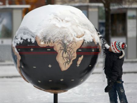 A boy cleans the snow from a globe in Copenhagen December 17, 2009. Copenhagen is the host city for the United Nations Climate Change Conference 2009, which lasts from December 7 until December 18.