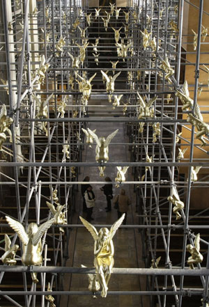 Church visitors stand under 300 golden angels attached to scaffolding during an exhibition in the Holy Cross church in Munich December 17, 2009. The installation known as &apos;Guardian angel over Munich&apos; by German artist Ottmar Hoerl runs until February 2, 2010. 