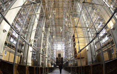 A visitor passes under 300 golden angels attached at scaffolding during an exhibition in the Holy Cross church in Munich December 17, 2009. The installation known as &apos;Guardian angel over Munich&apos; by German artist Ottmar Hoerl runs until February 2, 2010.