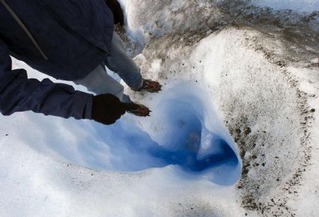 Tourist guide Ceferino Llamu stands on the edge of a crack on Argentina&apos;s Perito Moreno glacier near the city of El Calafate, in the Patagonian province of Santa Cruz, December 16, 2009.