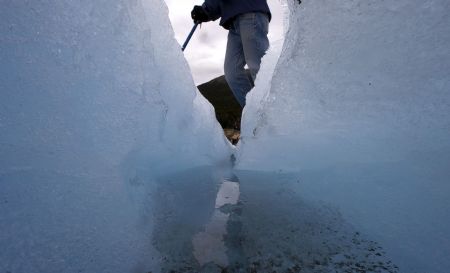 Tourist guide Ceferino Llamu stands over a crack on Argentina&apos;s Perito Moreno glacier near the city of El Calafate, in the Patagonian province of Santa Cruz, December 16, 2009.