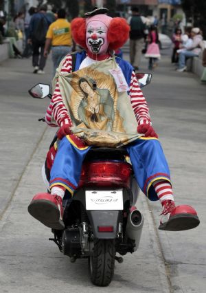 A clown carries an image of the Virgin of Guadalupe, patron saint of Mexican Catholics, as he takes part an annual pilgrimage near the Basilica of Guadalupe in Mexico City December 16, 2009.