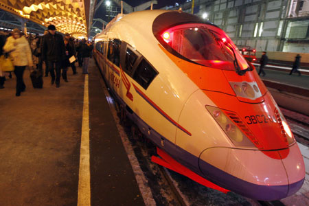 Passengers walk past Russia&apos;s first high speed train Sapsan in St Petersburg December 17, 2009. Travelling at up to 250 km (155 miles) an hour, the Sapsan will cut the journey time between Russia&apos;s two main cities of Moscow and St Petersburg to three hours 45 minutes from at least four and a half hours, delighting business travellers.