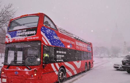 A sightseeing bus passes in front of the Capitol Hill during a snowstorm blanketing the East Coast in Washington D.C., Dec. 19, 2009. Forecasts called for up to 50 centimetres of snow across the region, including Washington, Baltimore, Philadelphia and reaching up to New York. (Xinhua/Zhang Yan)