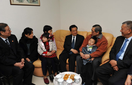 Chinese President Hu Jintao (4th R) visits local resident Leong Chi Sam's home in Macao Special Administrative Region (SAR) in south China on Dec. 19, 2009. (Xinhua