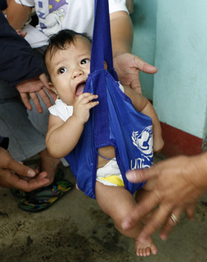 A baby of an evacuee is weighed during a medical check-up by UNICEF at a temporary shelter for residents living at the slopes of the Mayon Volcano in Legaspi city, about 500 km (310 miles) south of Manila December 21, 2009. The Philippines raised the alert level around the country&apos;s most active volcano on Sunday, warning of a possible hazardous eruption within days and extending a &apos;no-go zone&apos; up to 10 km (6 miles). [Xinhua/Reuters]