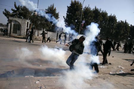 Supporters of the Unified Communist Party of Nepal (Maoist) (UCPN-M) throw back teargas shell to the police during a clash in Kathmandu, capital of Nepal, Dec. 20, 2009. Members of the UCPN-M and their supporters Sunday engaged in violent clashes with riot police, on the first day of the UCPN-M&apos;s three-day nationwide strike. (Xinhua/Bimal Gautam)