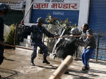 Nepalese police baton a demonstrator during a clash in Kathmandu, capital of Nepal, Dec. 20, 2009. Members of the Unified Communist Party of Nepal (Maoist) (UCPN-M) and their supporters Sunday engaged in violent clashes with riot police, on the first day of the UCPN-M&apos;s three-day nationwide strike. (Xinhua/Bimal Gautam)