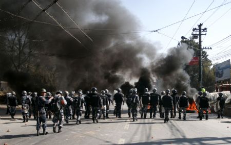 Nepalese police patrol the street during a clash in Kathmandu, capital of Nepal, Dec. 20, 2009. Members of the Unified Communist Party of Nepal (Maoist) (UCPN-M) and their supporters Sunday engaged in violent clashes with riot police, on the first day of the UCPN-M&apos;s three-day nationwide strike. (Xinhua/Bimal Gautam)