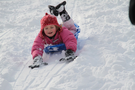 A girl slides on snow in the Central Park in New York City, the U.S., Dec. 20, 2009. People walked outdoors to enjoy the sunny weather on Sunday morning after an overnight blizzard rocked the city.(Xinhua/Wang Yongkang)