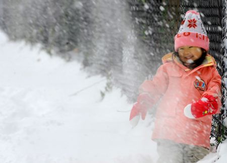 A Japanese girl plays with snow in a park in New York City, the U.S., Dec. 20, 2009.(Xinhua/Niu Hairong)