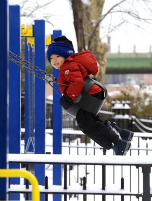 A girl plays the swing in a park in New York City, the U.S., Dec. 20, 2009.(Xinhua/Niu Hairong)