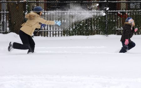 A girl and her mother play with snow in a park in New York City, the U.S., Dec. 20, 2009.(Xinhua/Niu Hairong)