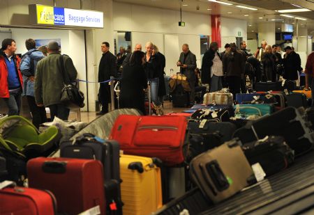 Passengers queue at an airport in Brussels, capital of Belgium, on Dec. 20, 2009.(Xinhua/Wu Wei)