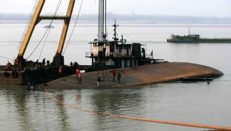 Rescuers salvage a capsized sand carrier vessel on Jingkou section of the Yangtze River, in Jiangxia District of Wuhan, central China&apos;s Hubei Province, Dec. 20, 2009.(Xinhua Photo)