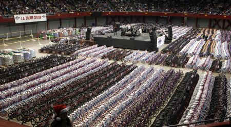 L.A. Dream Center Volunteer Kris Lee wears a santa hat as thousands of bikes and toys are seen on the floor of the LA Sports Arena in Los Angeles, California, December 20, 2009. Thousands of bicycles and toys were given away to families in need during The Dream Center Christmas in the City event.