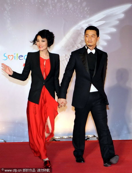 Li Yapeng and pop queen Faye Wong walk the red carpet at the Smile Angel Fund charity dinner in Beijing on December 18, 2009.