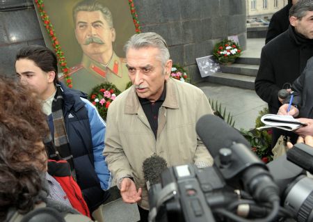 The grandson of Josef Stalin, Yevgeny Jugashvili (C) is interviewed in front of the portrait of Josef Stalin in Gori, Georgia, Dec. 21, 2009. Some Georgians came to Gori, where Josef Stalin was born 130 years ago, to pay tribute to the Soviet leader on Monday.