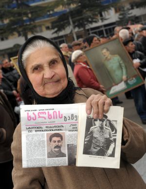 A woman displays books and newspaper introducing Josef Stalin during the memorial ceremony marking the 130th anniversary of his birthday in Gori, Georgia, Dec. 21, 2009. Some Georgians came to Gori, where Josef Stalin was born 130 years ago, to pay tribute to the Soviet leader on Monday.