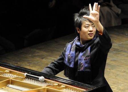 Chinese pianist Lang Lang plays a unison with 100 children as he visits Shenzhen in south China&apos;s Guangdong Province on Dec. 21, 2009.