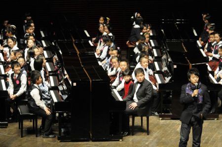 Chinese pianist Lang Lang speaks to young piano players as he visits Shenzhen of south China&apos;s Guangdong Province on Dec. 21, 2009. Lang Lang played a unison with 100 children in the city.