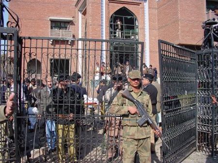 Security personnel stand guard at the site of blast in the northwestern Pakistani city of Peshawar, Dec. 22, 2009. 