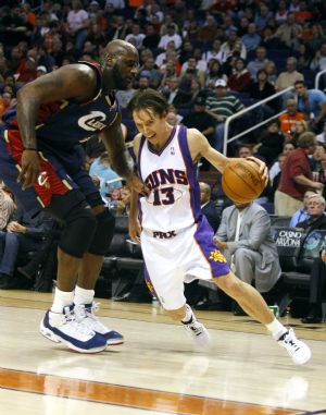 Phoenix Suns&apos; Steve Nash (R) drives on Cleveland Cavaliers&apos; Shaquille O&apos;Neal in the fourth quarter of an NBA basketball game in Phoenix, Arizona, December 21, 2009.(Xinhua/Reuters Photo)