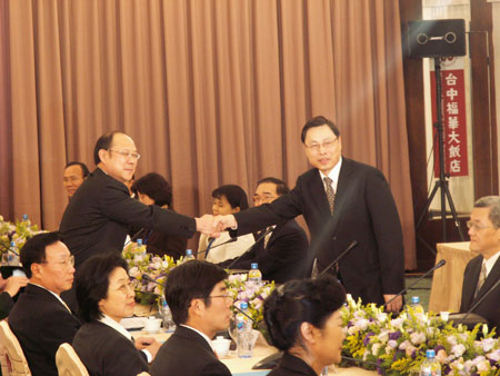 Zheng Lizhong (standing left), vice-president of the Chinese mainland's Association for Relations Across the Taiwan Straits (ARATS), and Kao Kung-lian, vice-chairman and secretary general of Taiwan's Straits Exchange Foundation (SEF), shake hands during a meeting in Taichung, December 21, 2009. 